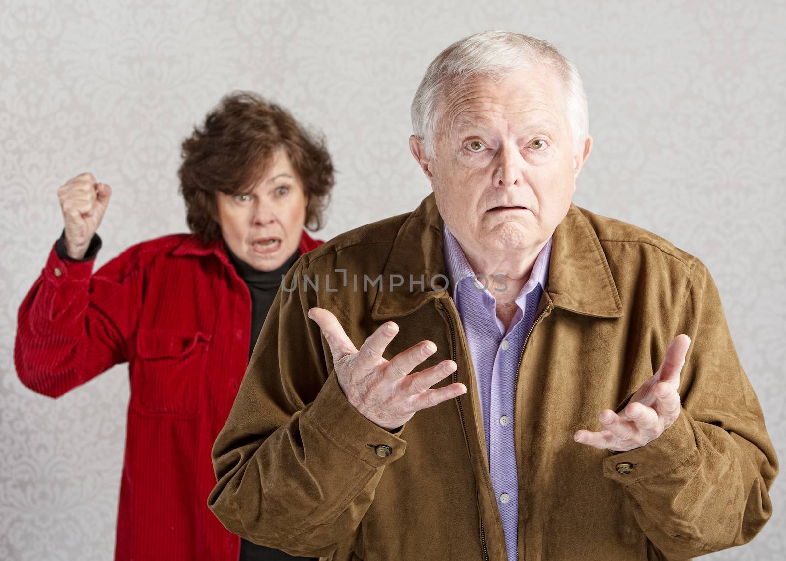Confused elderly man with angry older woman