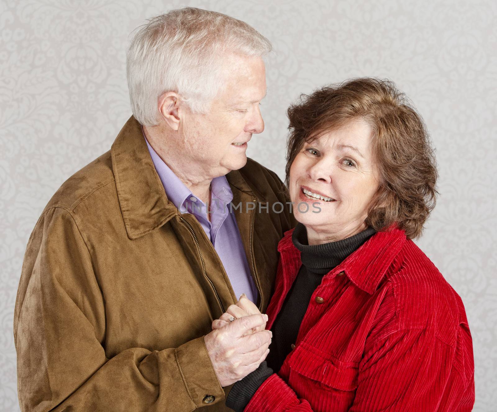 Husband looking at his smiling wife and holding hands