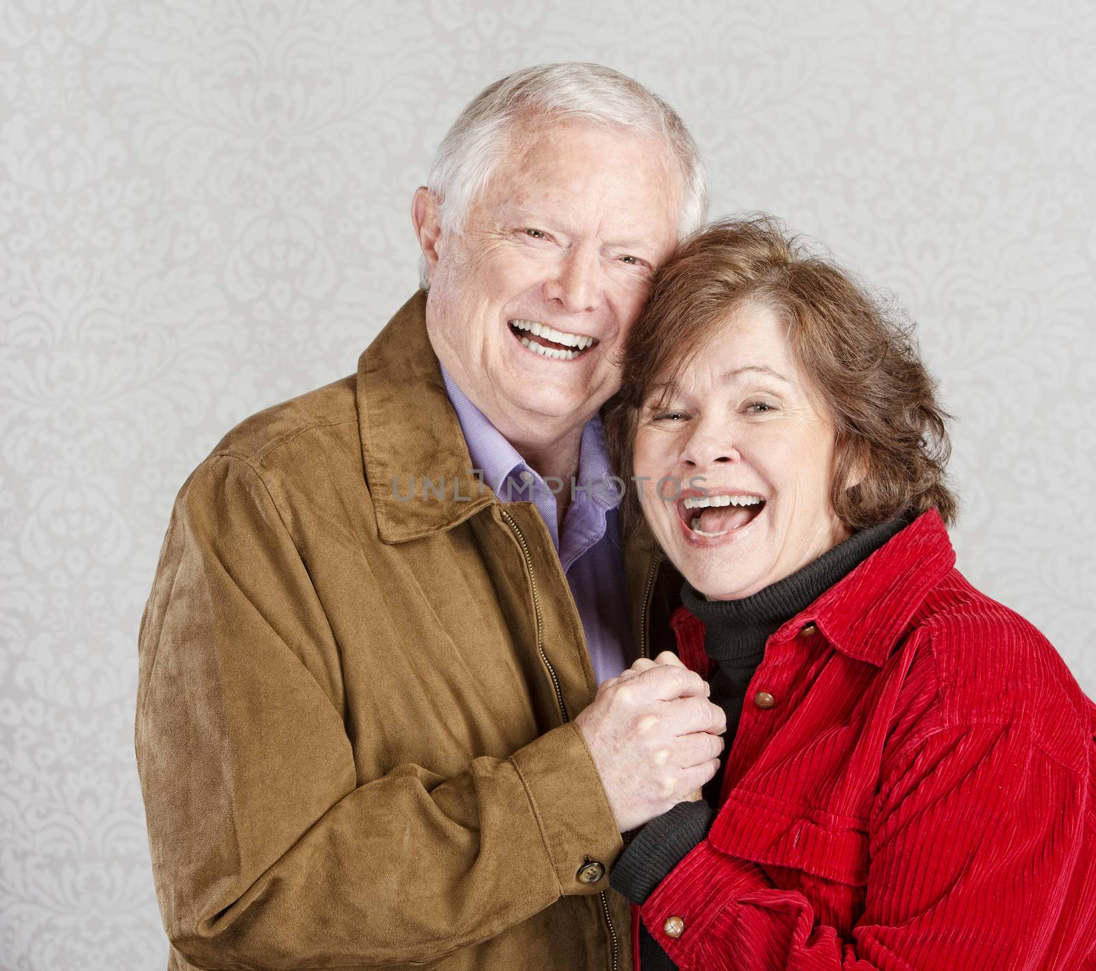 Laughing married man and woman holding hands