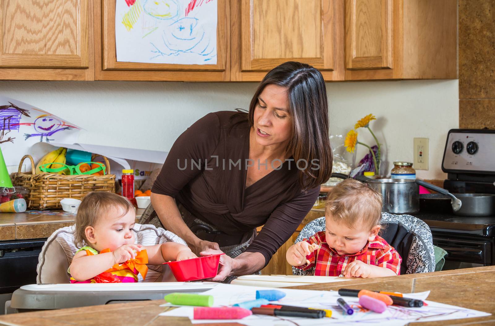 A mother in the kitchen feeds babies breakfast