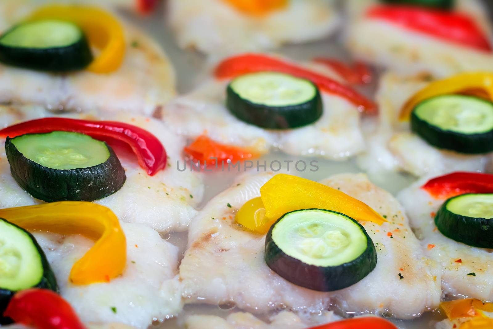 Appetizing portions of the roasted fish and vegetables: cucumbers and pepper.