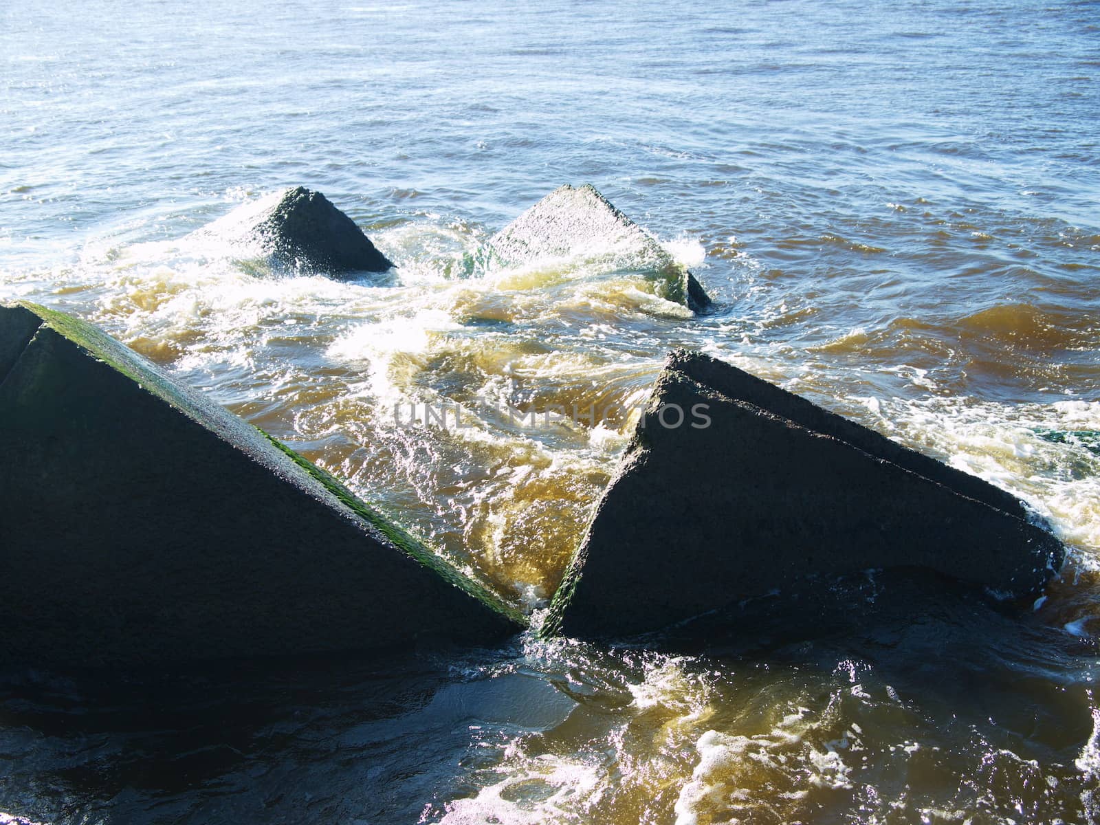 Clear sea water and the big stones surrounded with waves