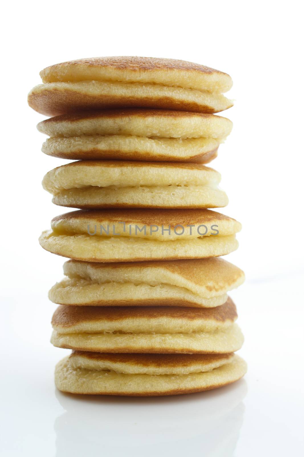 A stack of plain pancakes on a white background