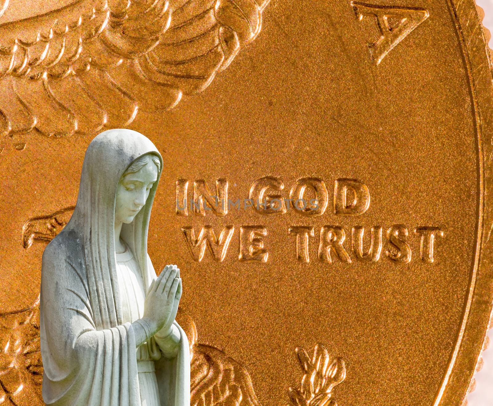 Image of statue of lady praying with US currency as background as a concept for the linkage of religion with money and wealth