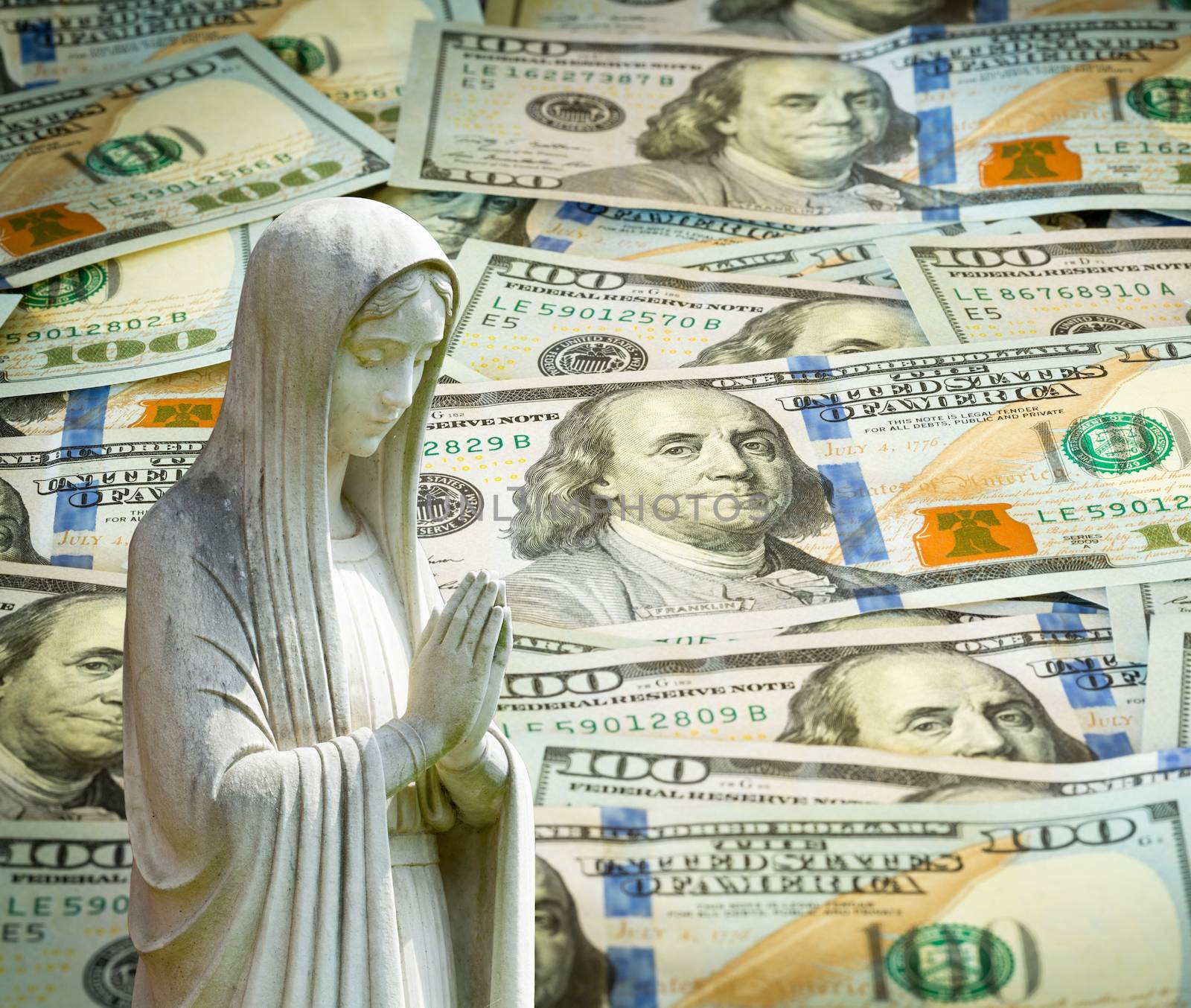 Image of statue of lady praying with US currency as background as a concept for the linkage of religion with money and wealth