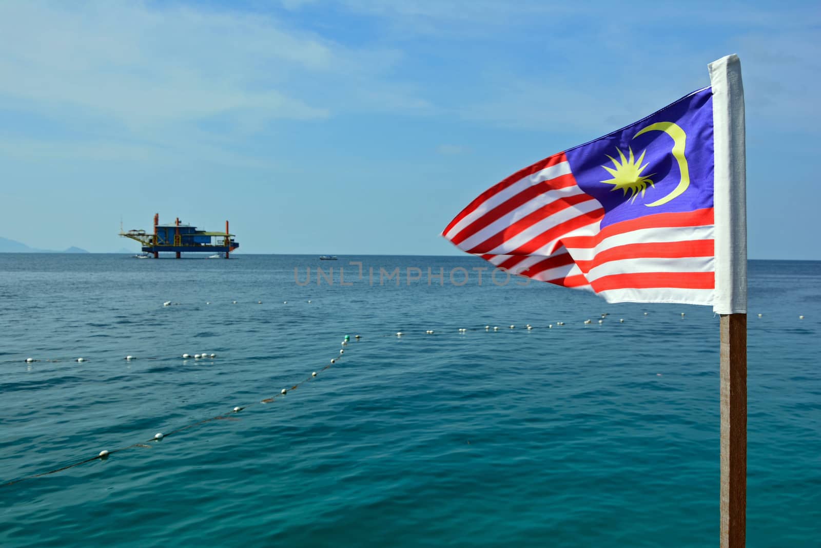 old rig in the ocean and flag at Mabul island, Malaysia by think4photop