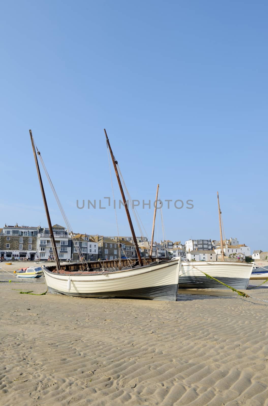 Traditional boats on sandy beach in St Ives Cornwall on a sunny summer day