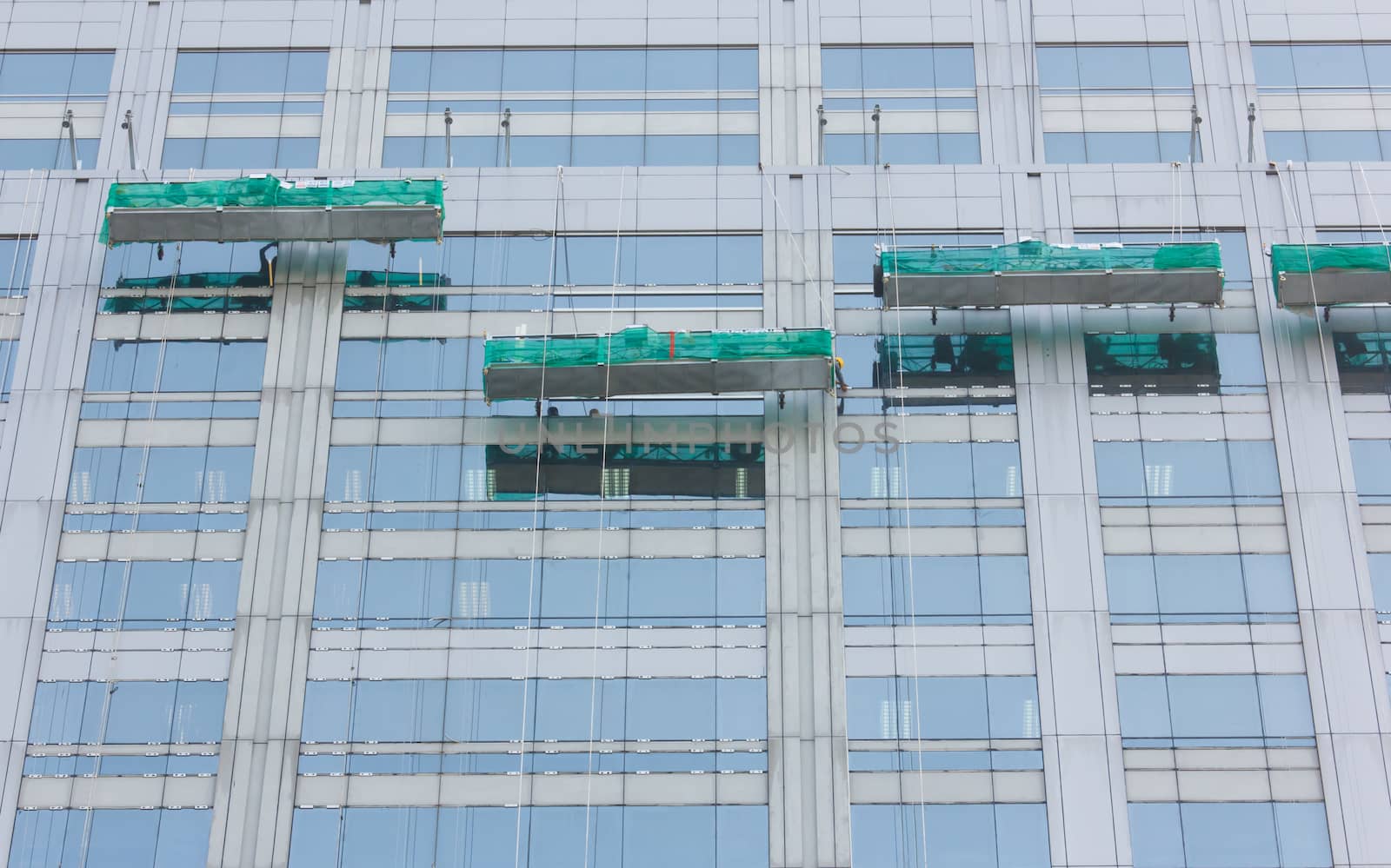 Worker cleaning windows of  building