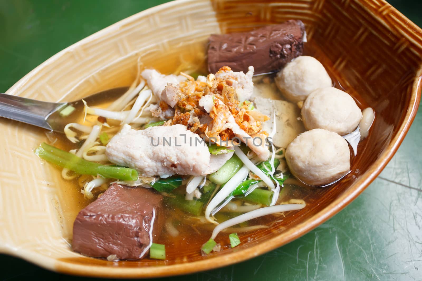 clear soup with pork and vegetables in bowl