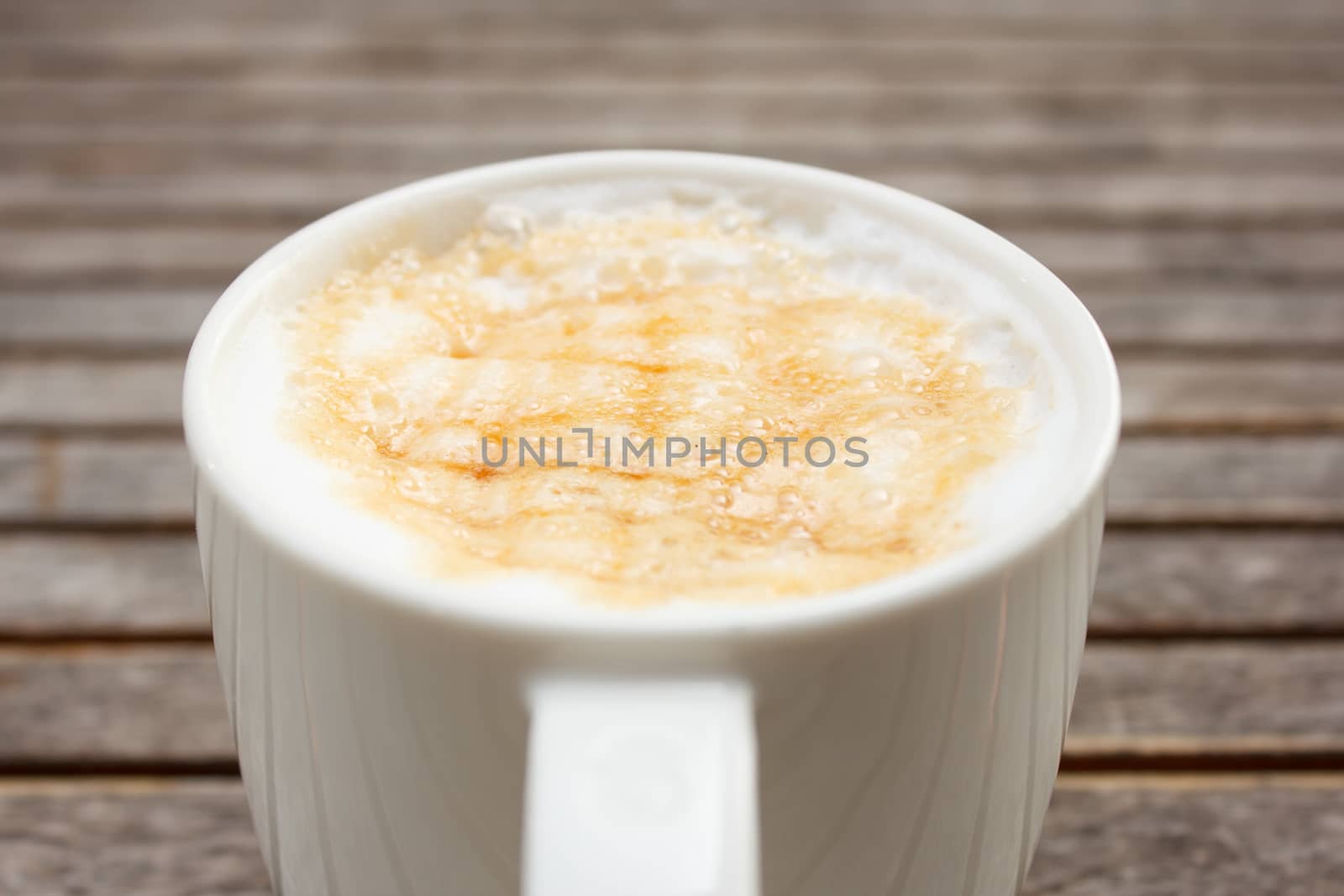 close up caramel microfoam on cup coffee