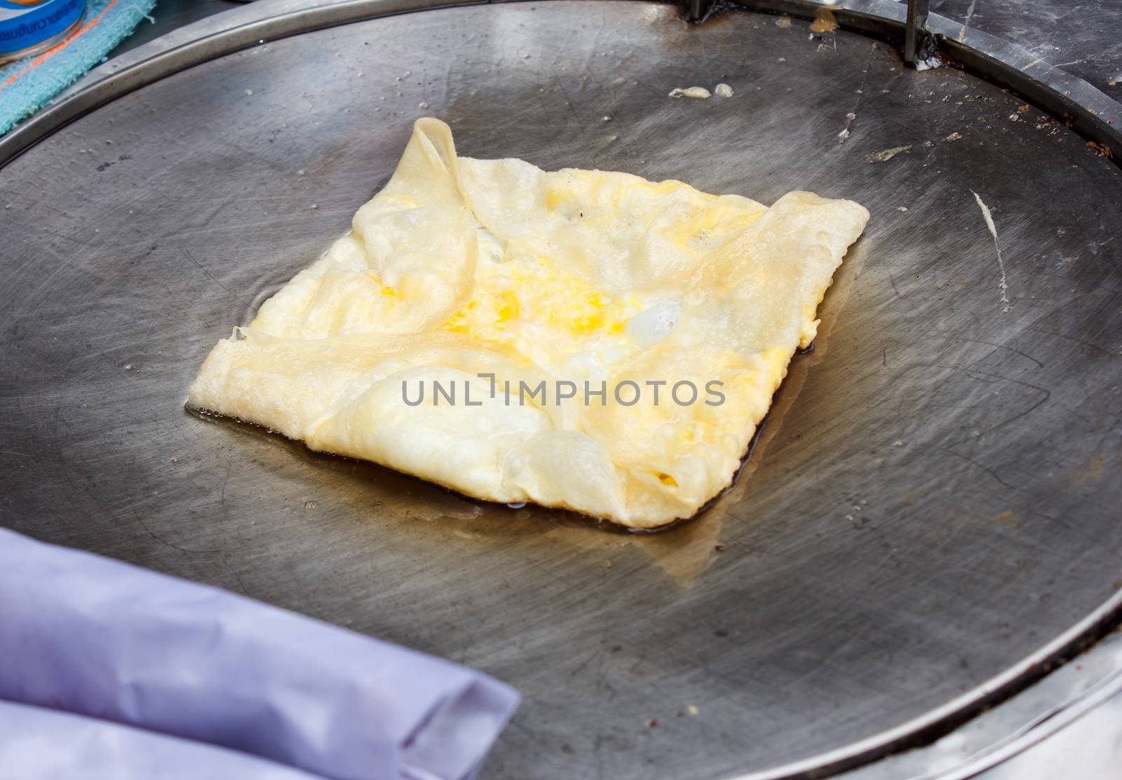 roti with egg frying on hot pan