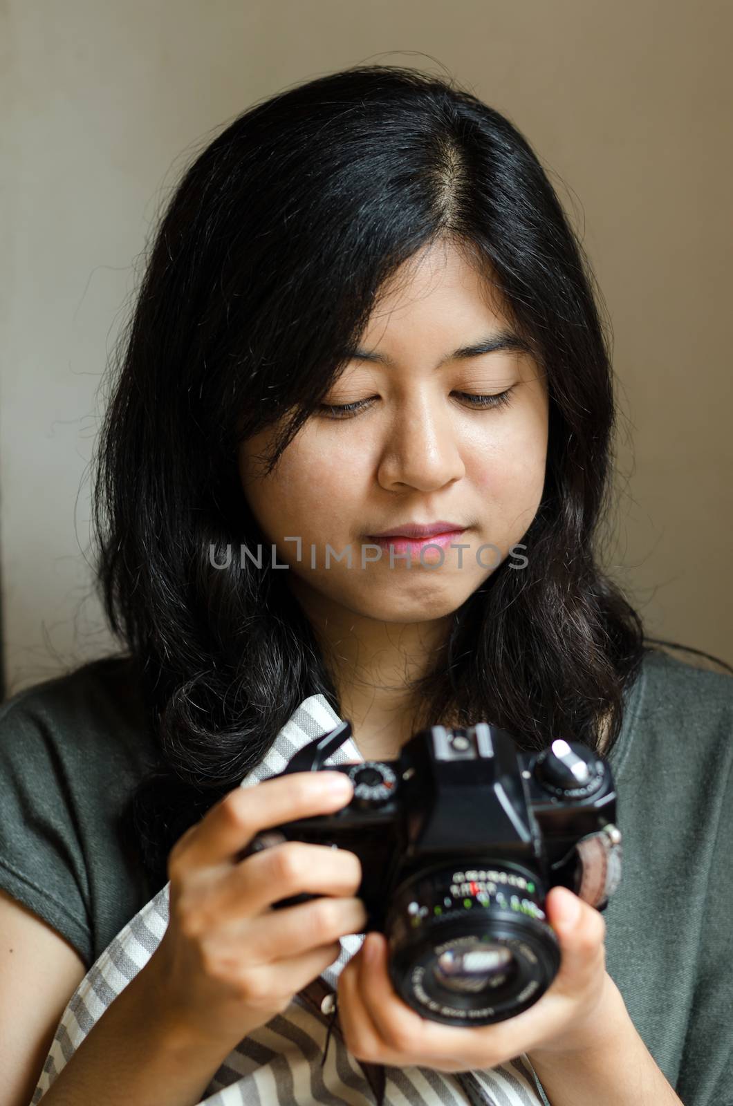 Woman holding an old film camera by siraanamwong