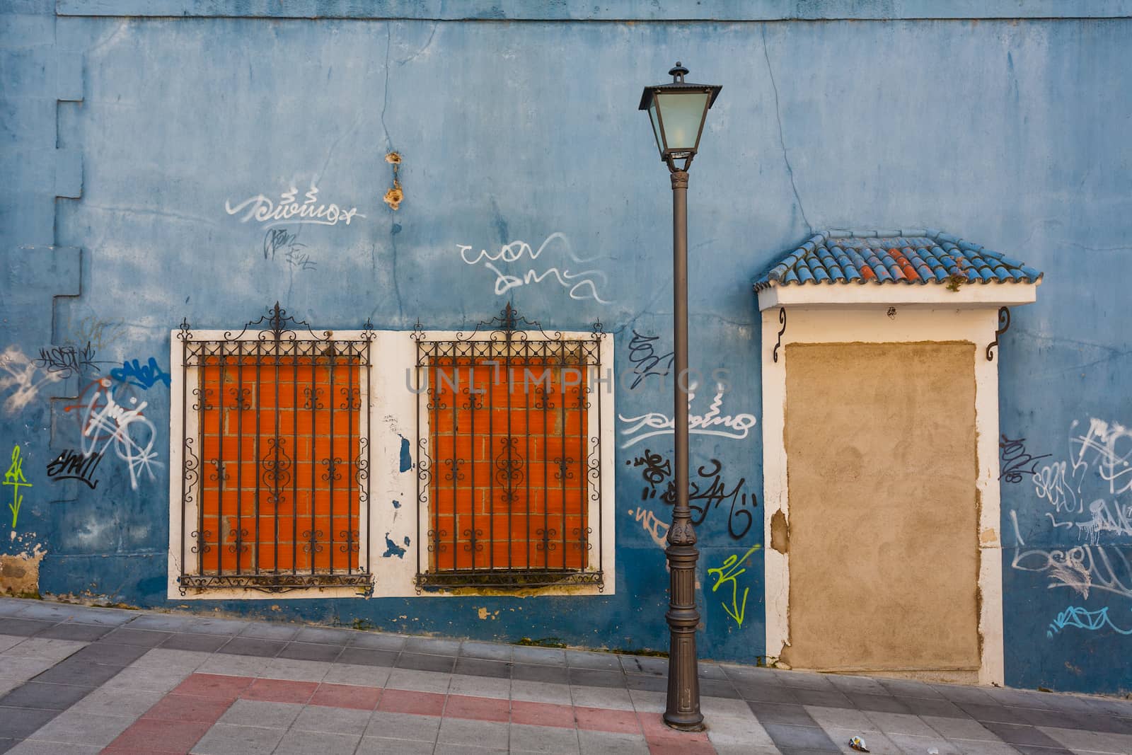 Curiosus image of a bricked up house with lamppost and graffitis in the street Salamance Spain