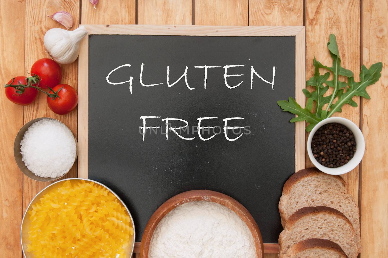 Gluten free sign handwritten on a chalk board surrounded by ingrediients