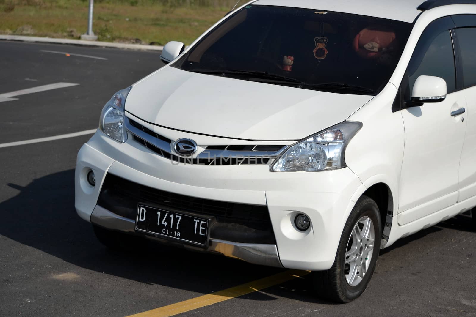 Bandung, Indonesia - August 1, 2014: White colored Daihatsu Xenia parked beside road.