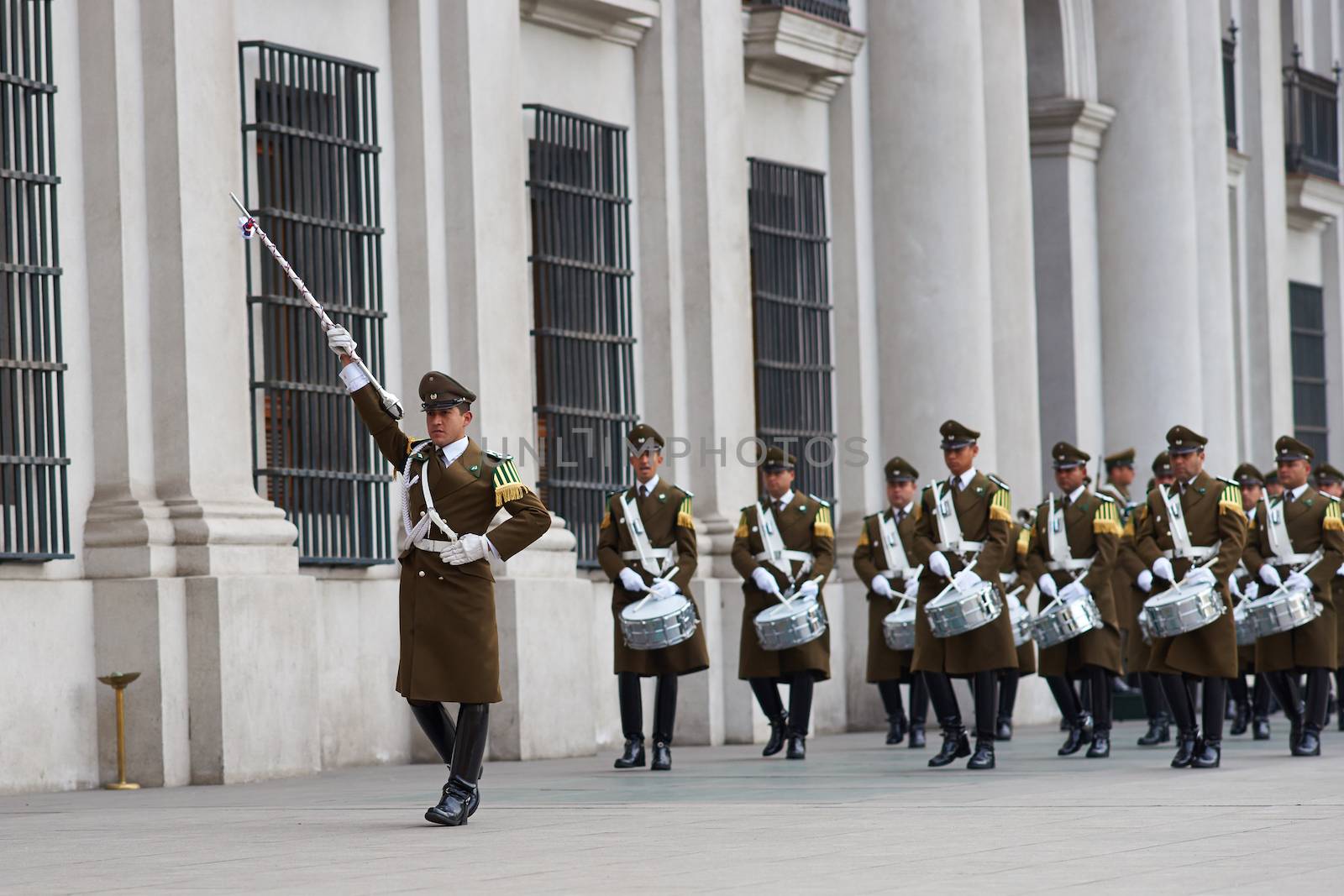 Female members of the Carabineros marching with a ceremonial flag as part of the changing of the guard ceremony at La Moneda in Santiago, Chile