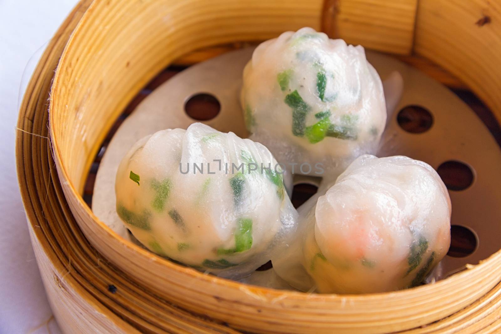 Dimsum in the steam basket . Chinese dimsum steamer prawn isolated on white background.