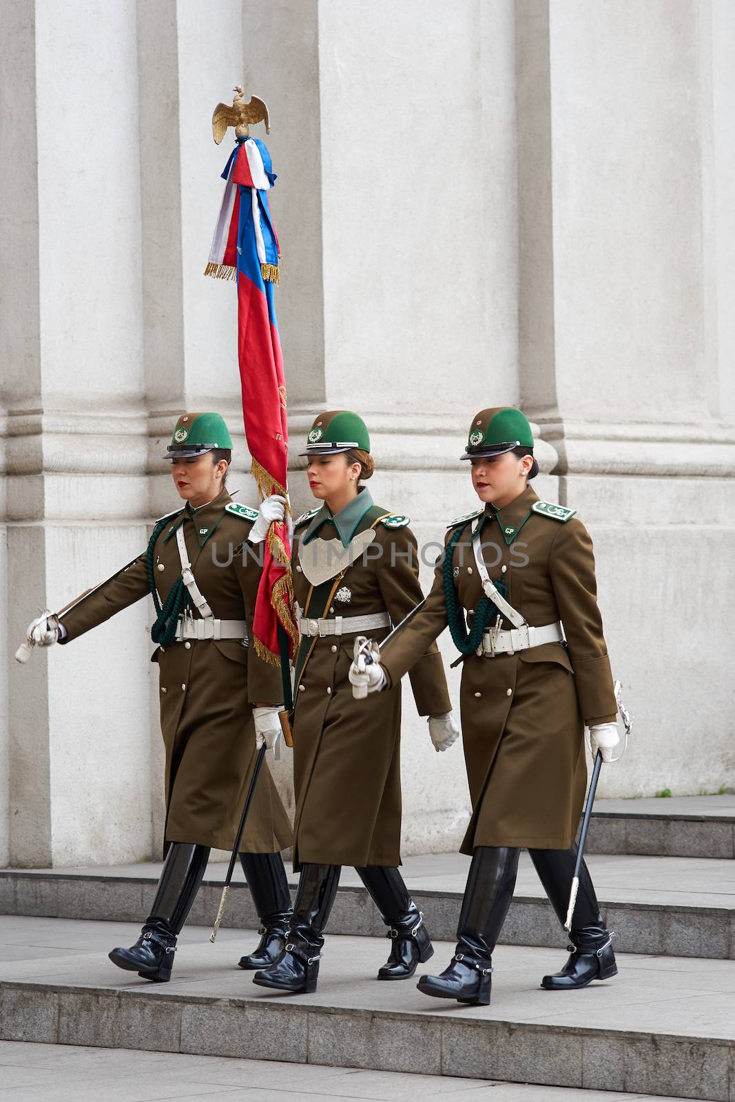 Female members of the Carabineros marching with a ceremonial flag as part of the changing of the guard ceremony at La Moneda in Santiago, Chile