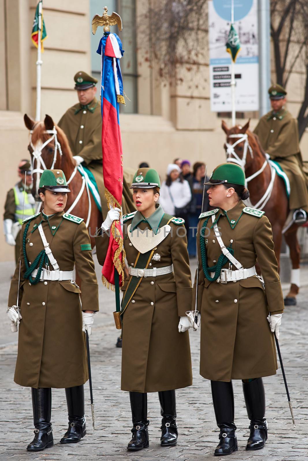 Female members of the Carabineros marching with a ceremonial flag as part of the changing of the guard ceremony at La Moneda in Santiago, Chile