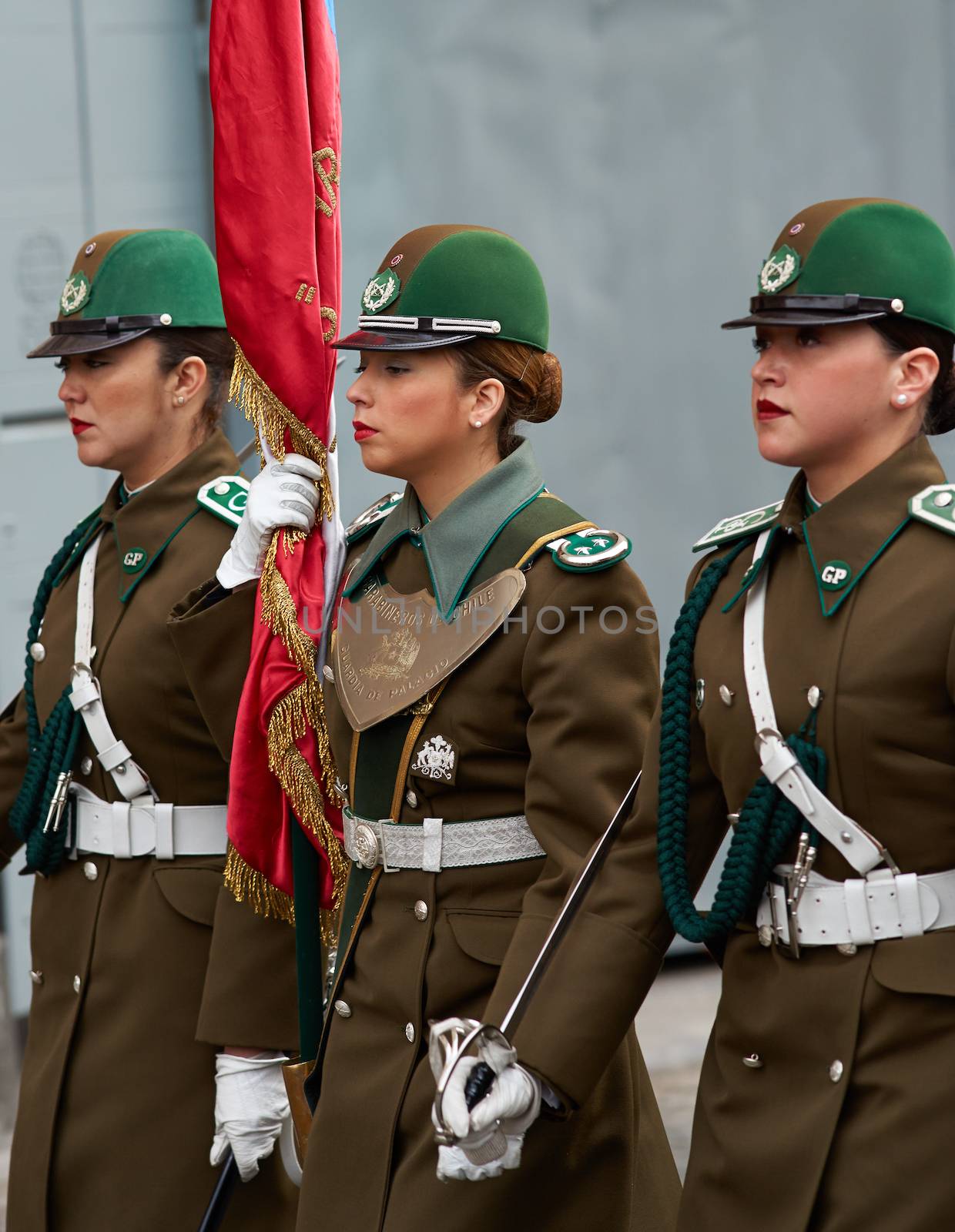 Female members of the Carabineros marching with a ceremonial flag as part of the changing of the guard ceremony at La Moneda in Santiago, Chile
