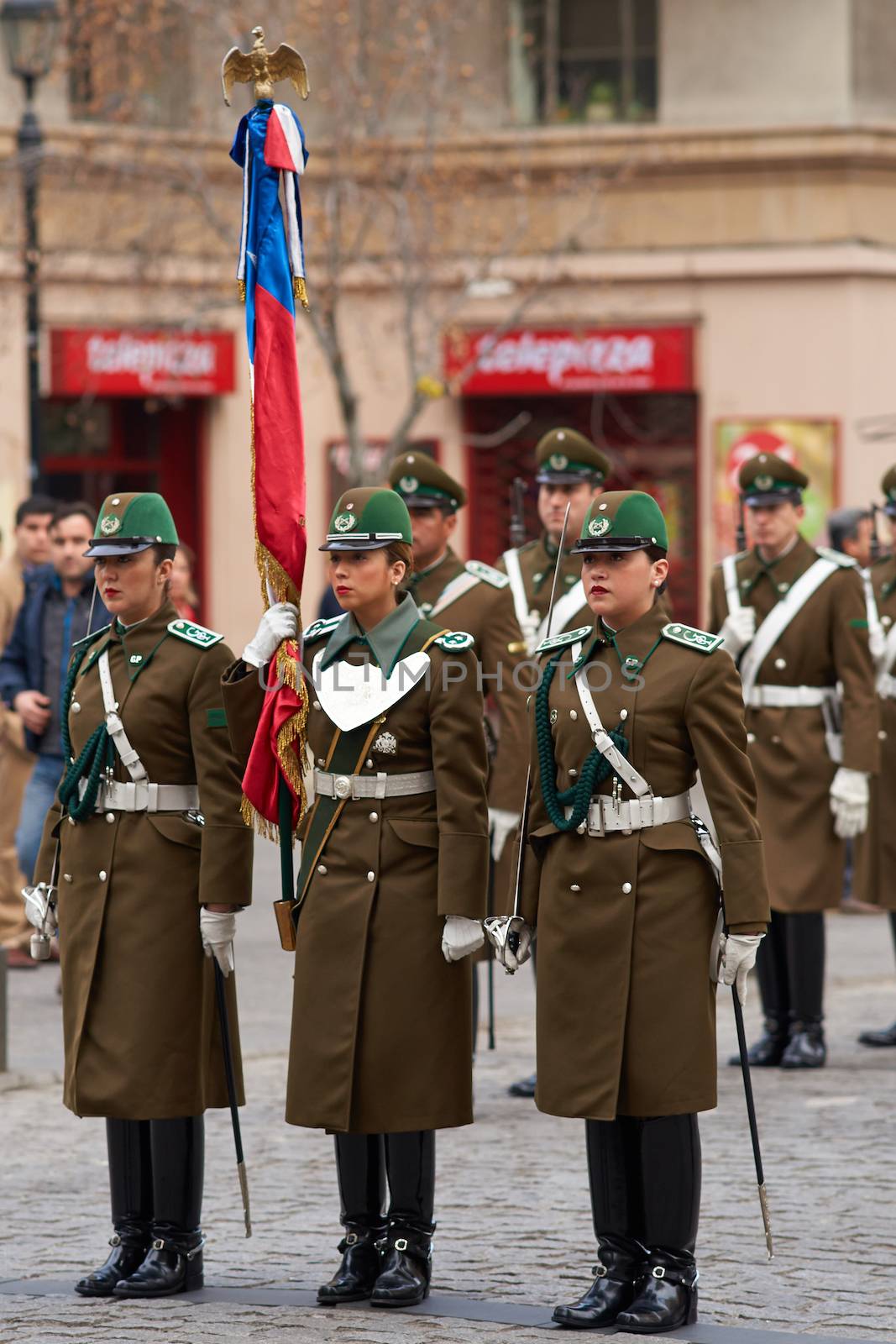 Female members of the Carabineros marching with a ceremonial flag as part of the changing of the guard ceremony at La Moneda in Santiago, Chile