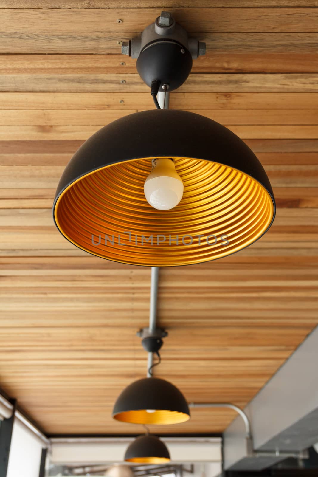 A modern lamp on wooden ceiling