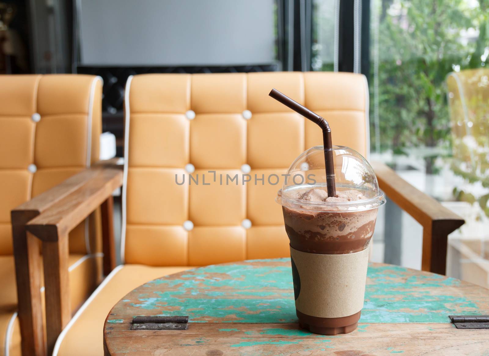Iced chocolate shake on wooden table at coffee shop