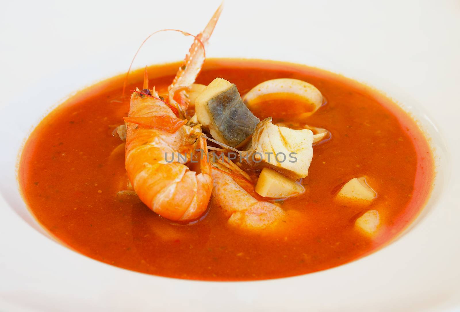 Stewed Bouillabaisse Soup with Delicious Seafood closeup in White Bowl