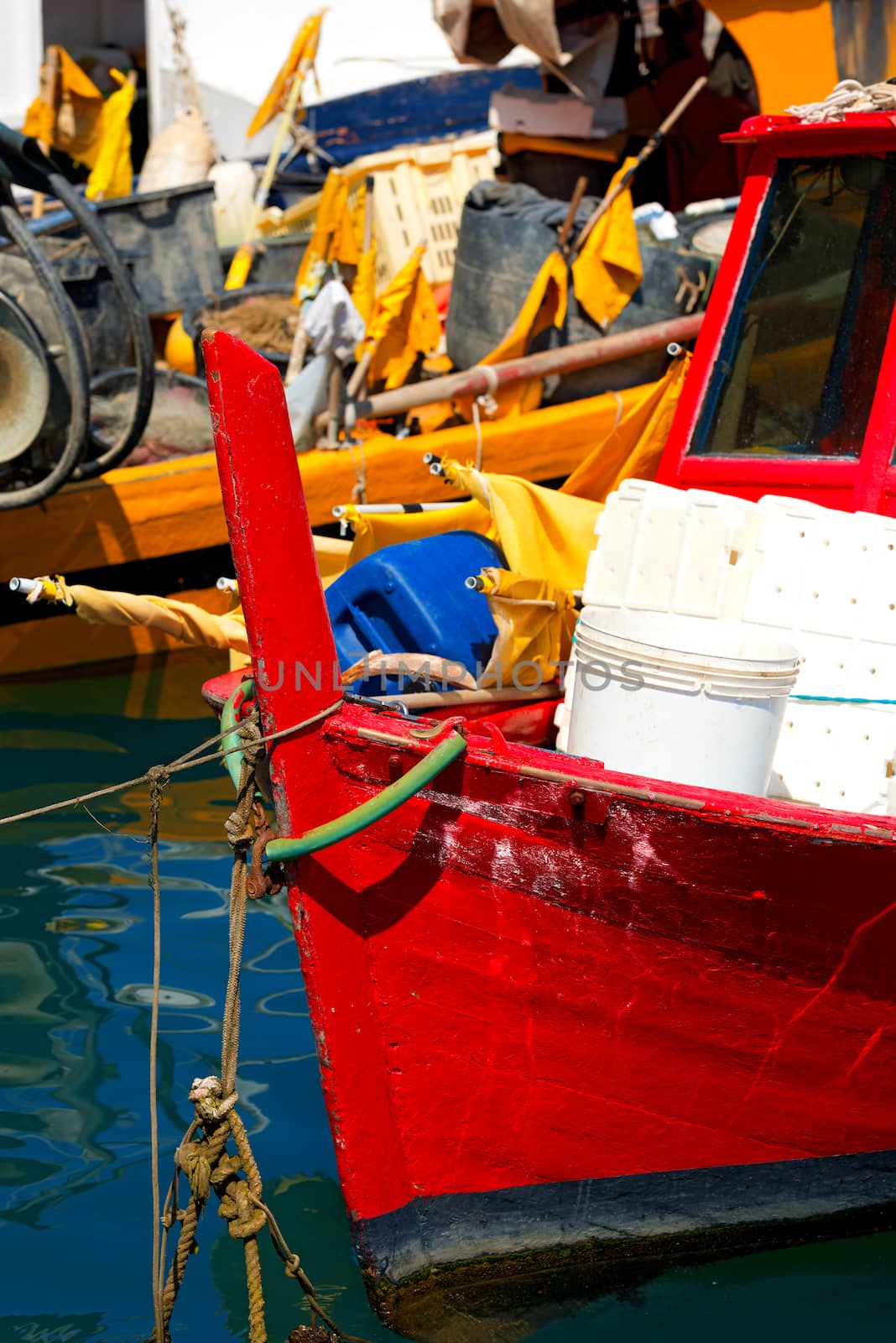 Red and yellow small fishing boats with fishing equipment docked in port - Lerici, La Spezia, Liguria, Italy