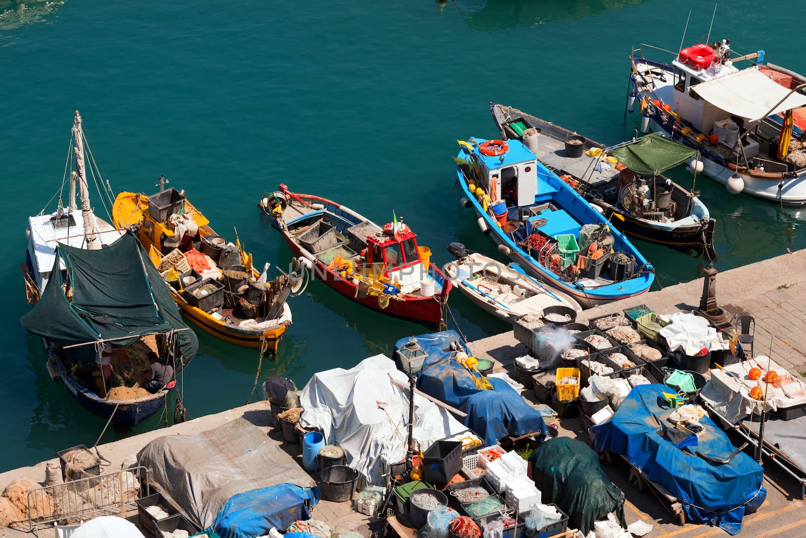 Many small fishing boats, red, yellow, blue and white with fishing equipment docked in port - Lerici, La Spezia, Liguria, Italy