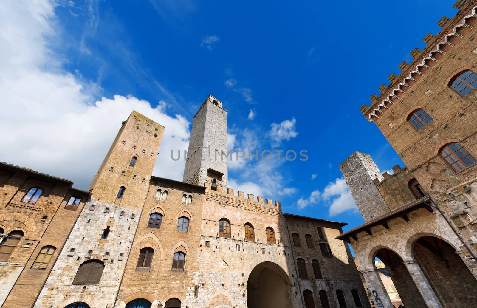 Buildings and towers in Piazza del Duomo, San Gimignano medieval town (UNESCO heritage), Siena, Tuscany, Italy