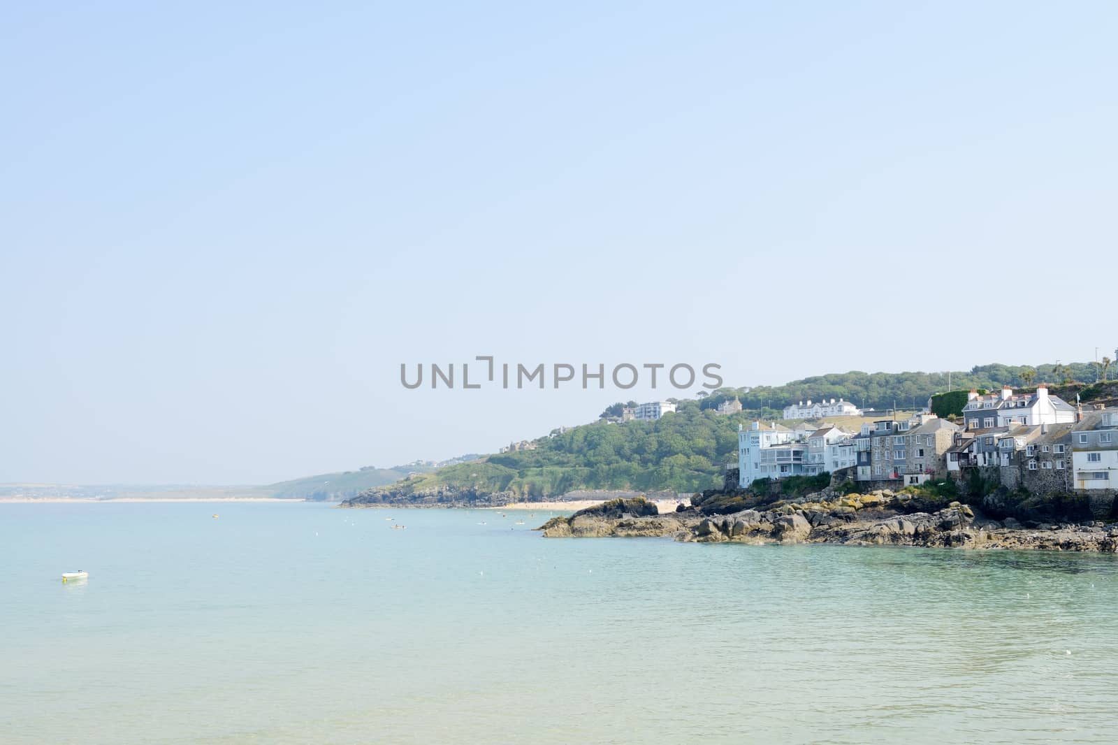 St Ives in Cornwall during the summer on a sunny day with blue sky and rocky shore