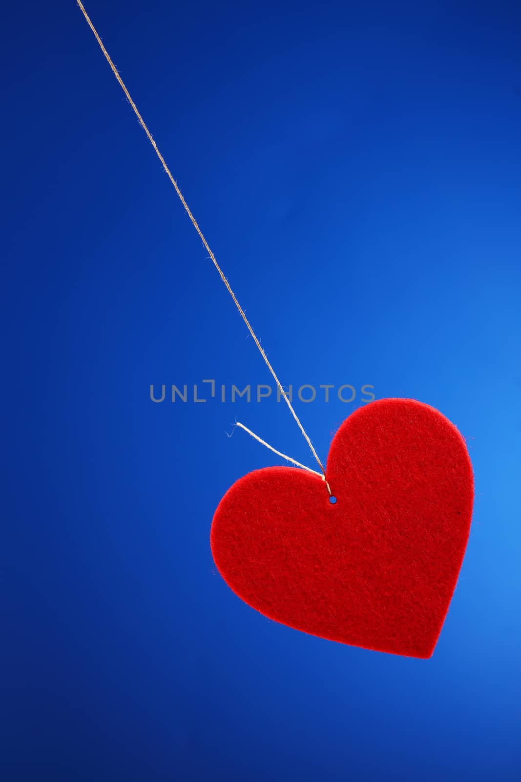 red shape heart  tied twine on blue background