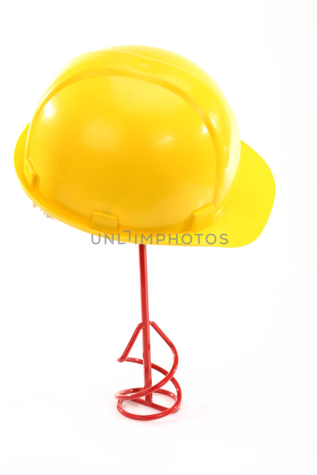 Yellow protective helmet and red industrial stirrer over white