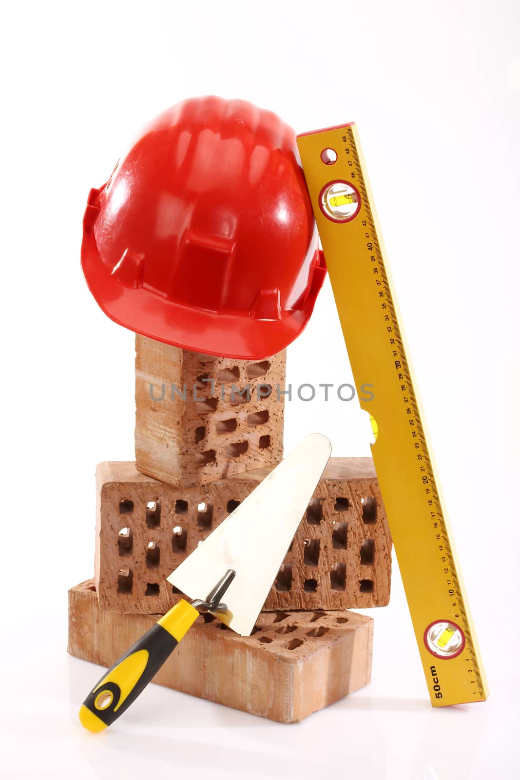 Bricks, trowel and helmet over white