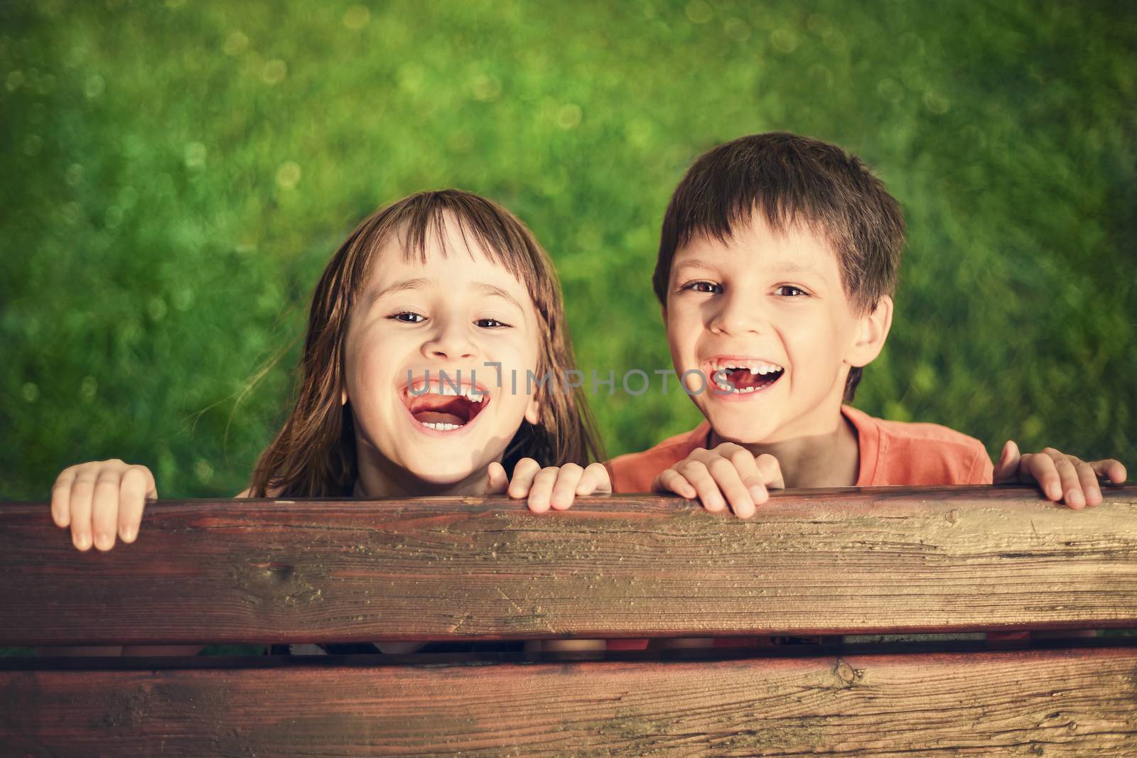 Outdoor portrait of smiling girl and boy who lost his milk teeth