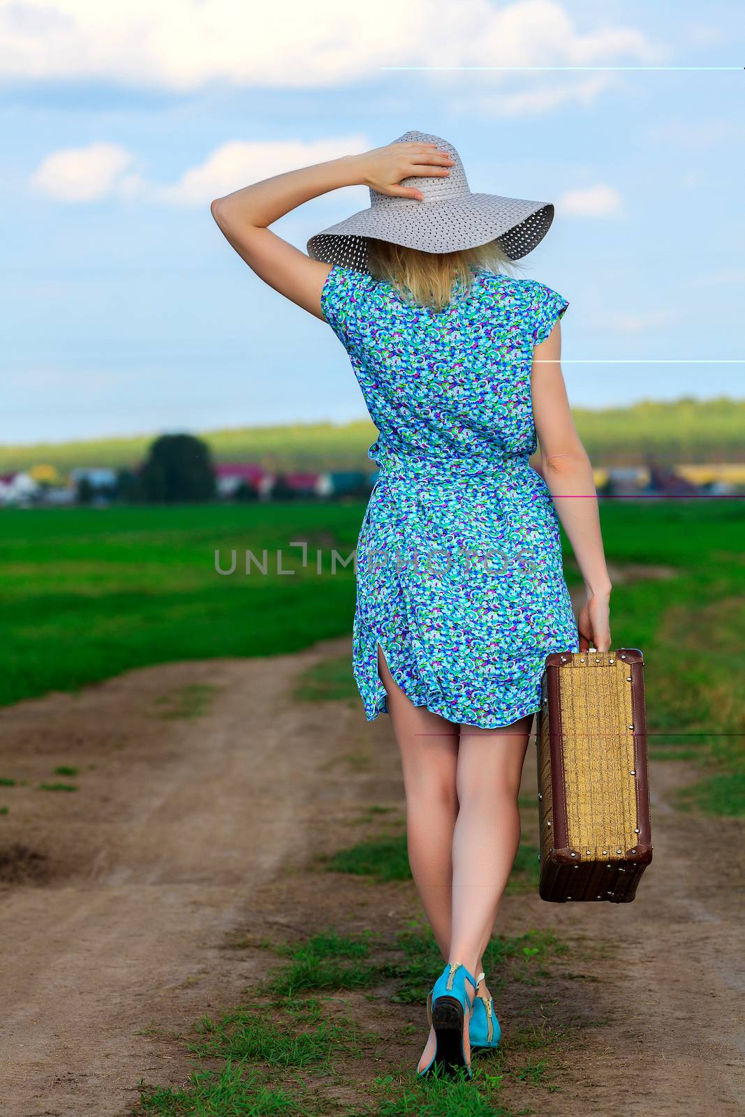Woman in summer dress with a suitcase