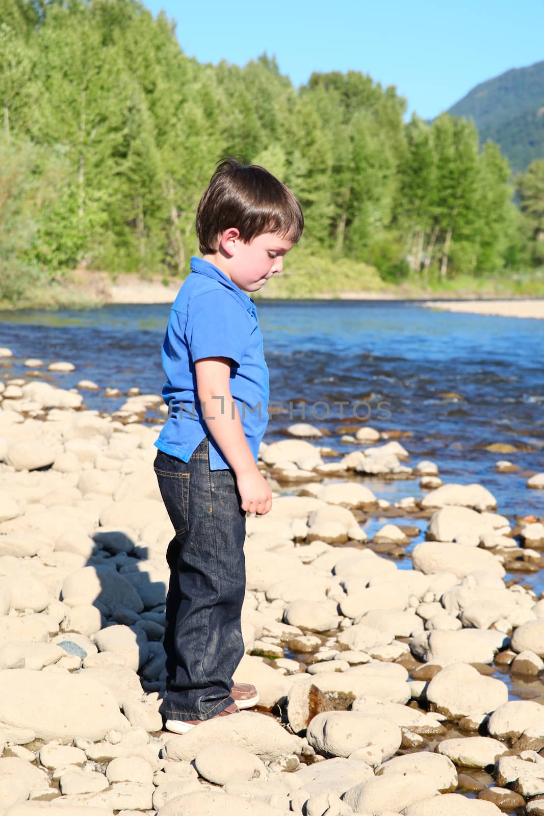 Younb boy playing outside on pebble beach