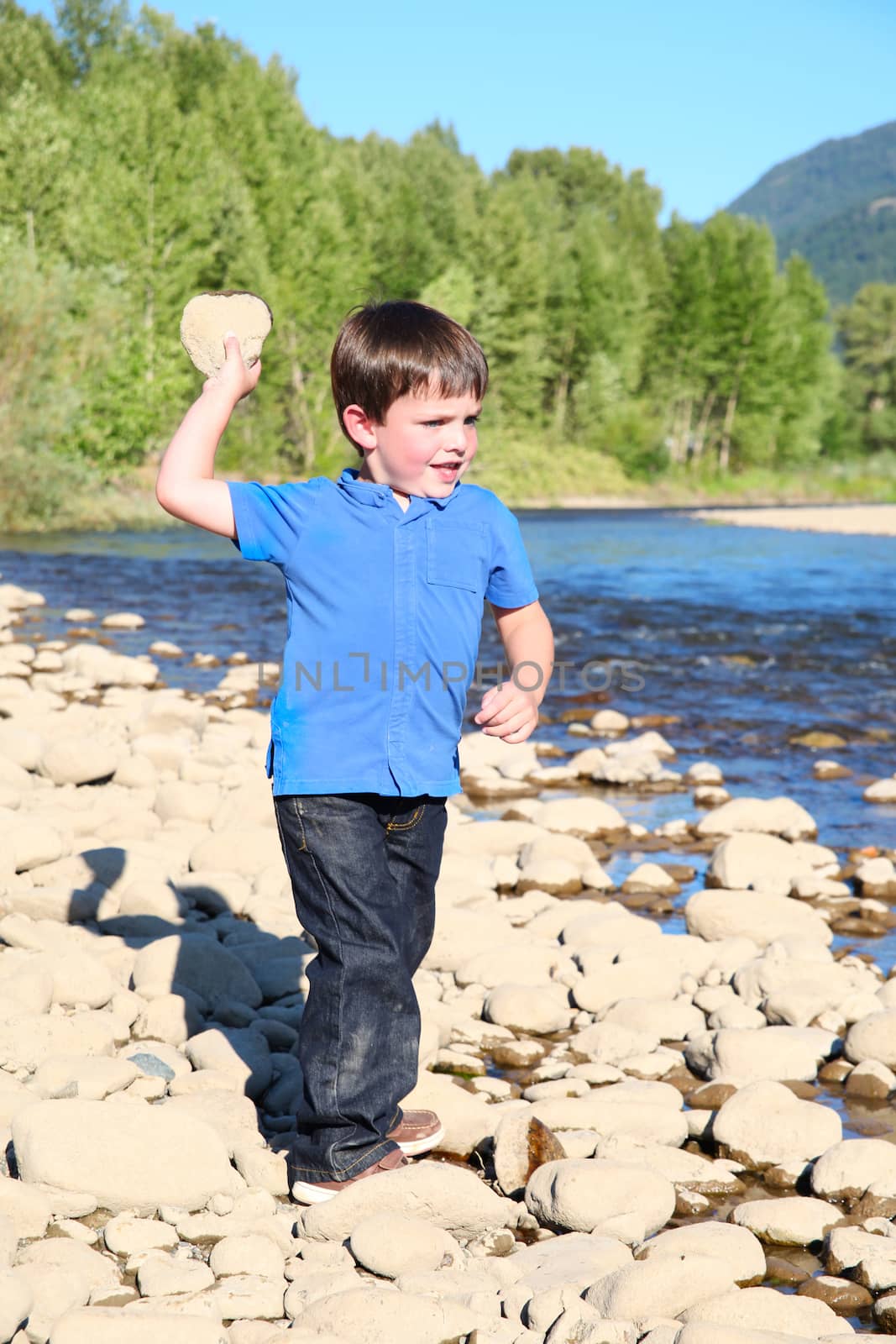 Younb boy playing outside on pebble beach