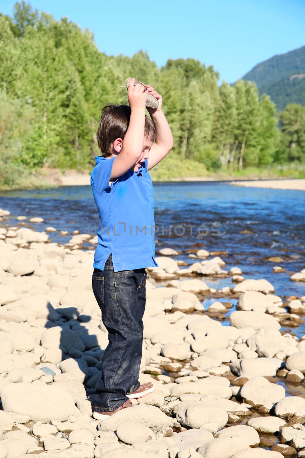 Younb boy playing outside on pebble beach