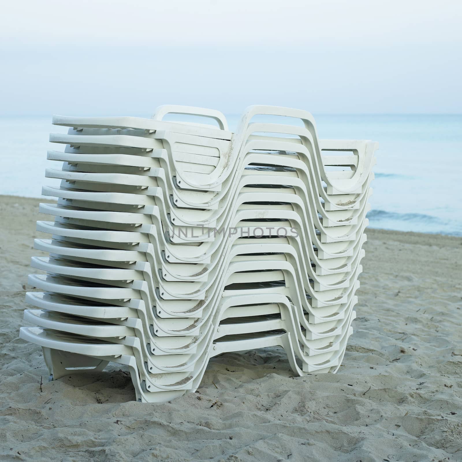 Pile of white lounging chairs by mmm
