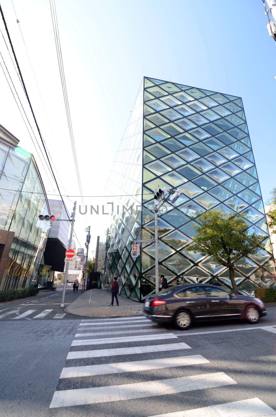 Tokyo, Japan - November 24,2013: Person walks by Prada store on November 24, 2013 in Omotesando, Tokyo. The Italian fashion company is present in 65 countries with 250 single brand shops. It was founded in 1913. 