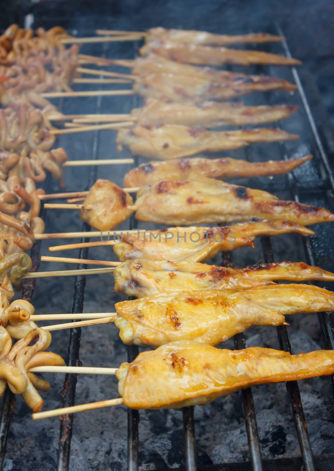 Chicken wing cooking on a hot grill stove (thai style)