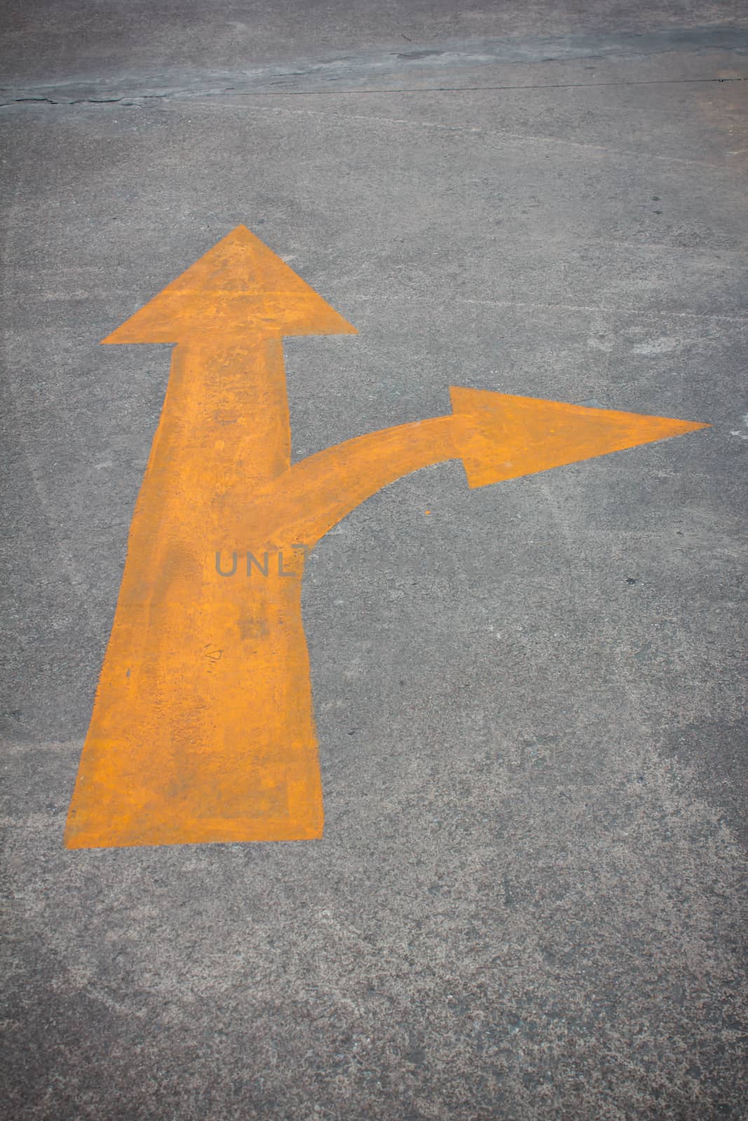 A yellow traffic arrow signage on the road