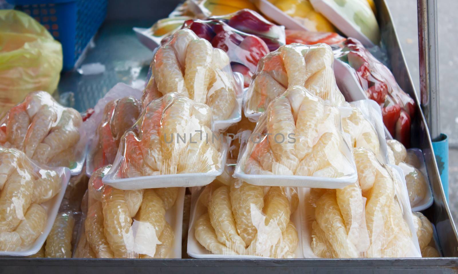 pomelo pieces in plastic wrap at market. Thailand
