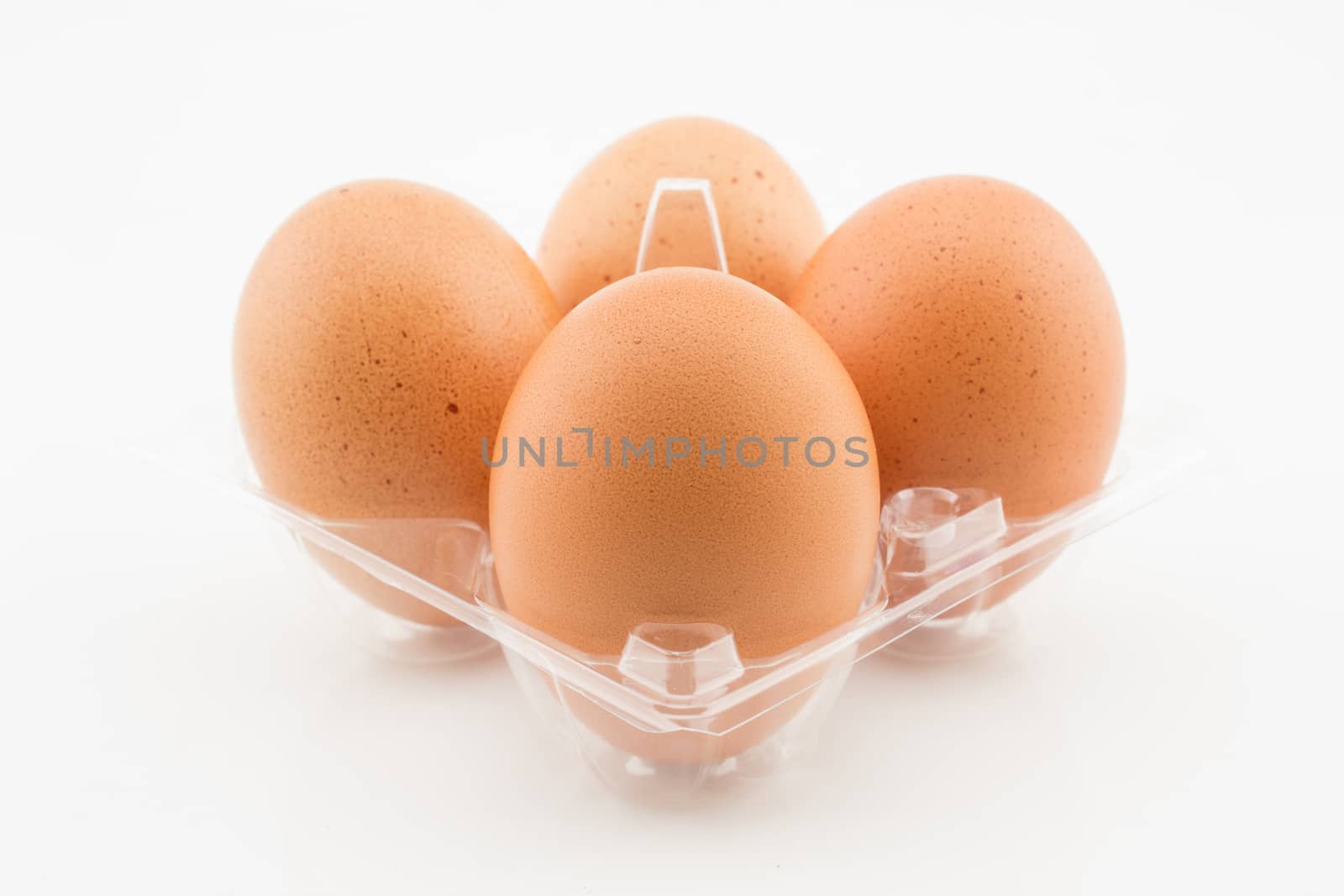 Four eggs in plastic tray packaging isolated on white background