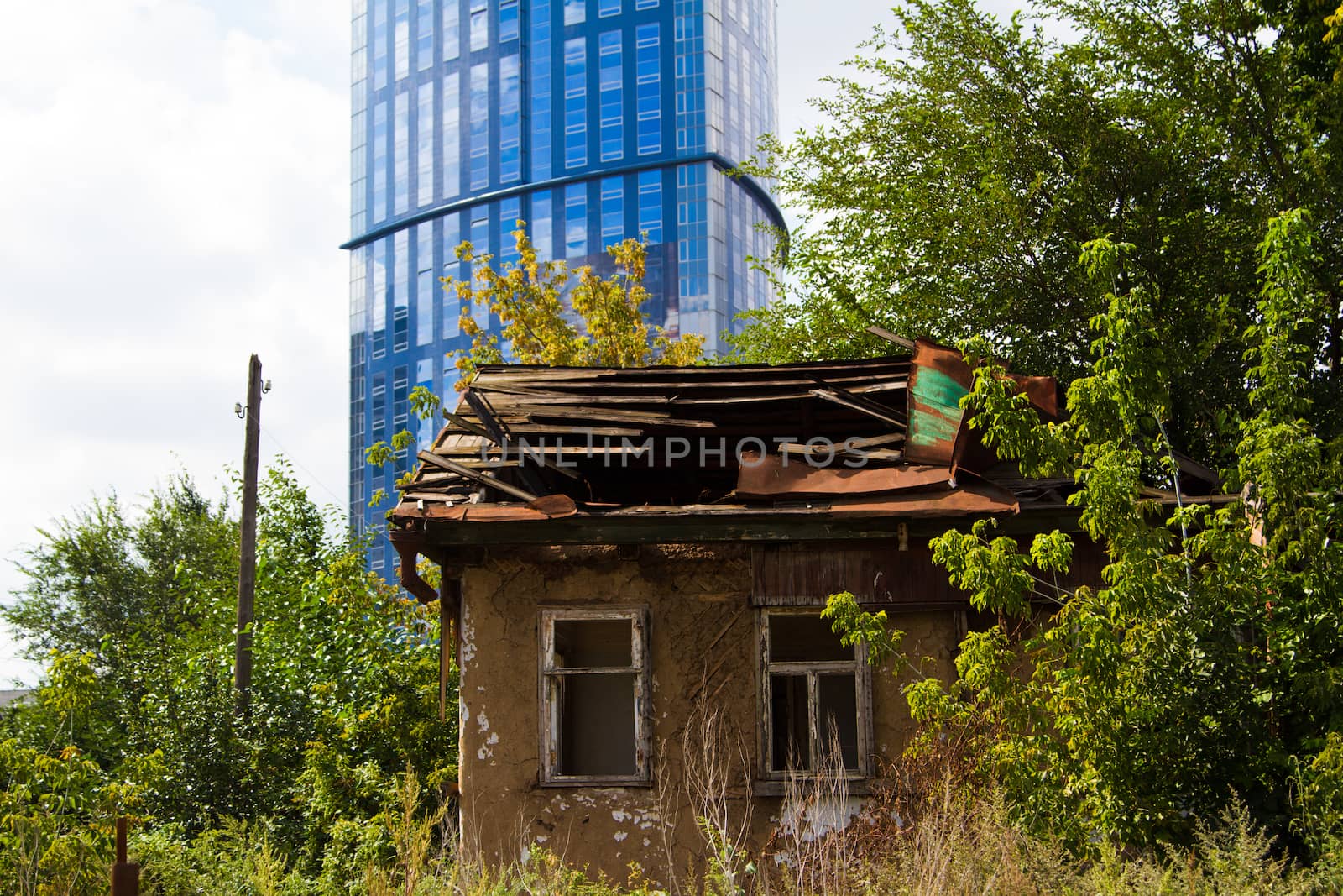 Old building in front of a modern skyscraper - Stock Image