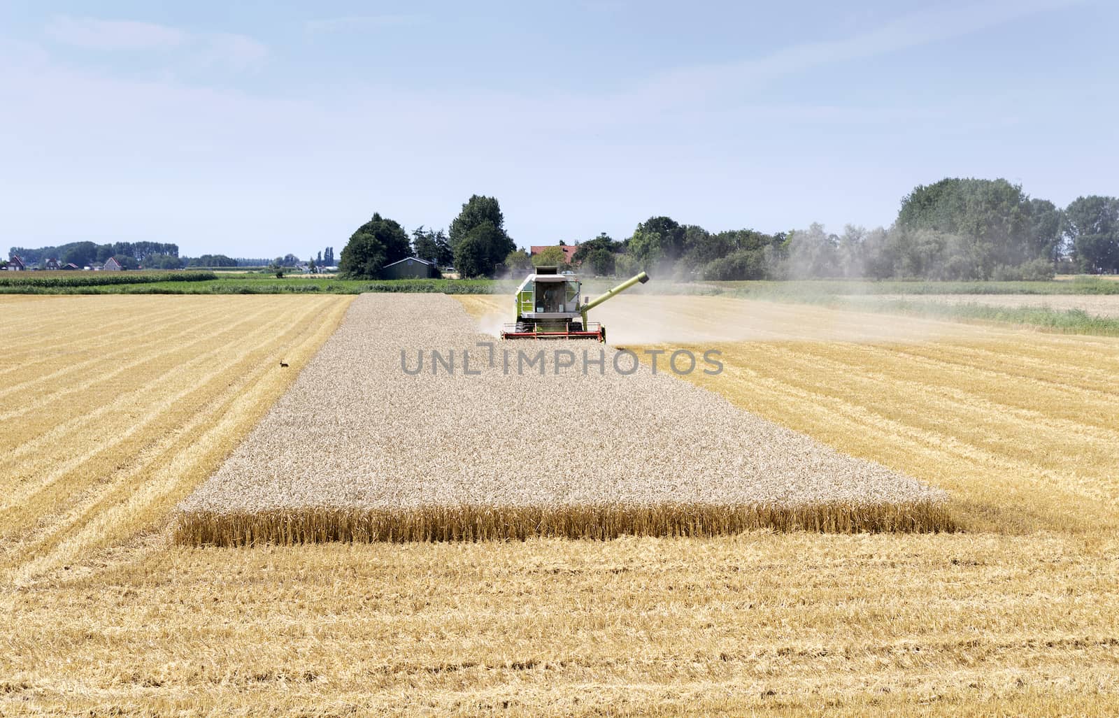 farmer with big machine on the land by compuinfoto