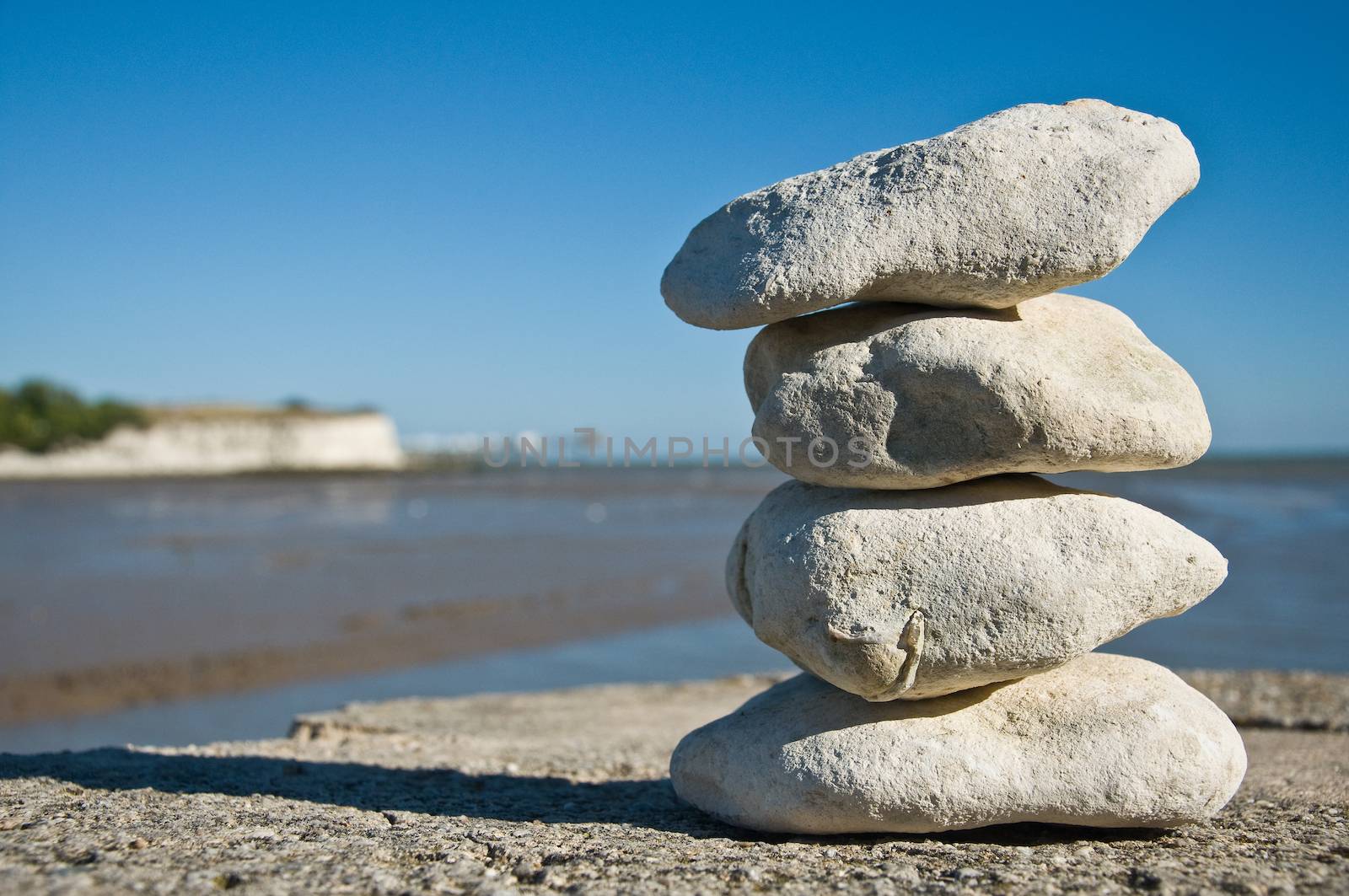 Pebbles on the beach by NeydtStock