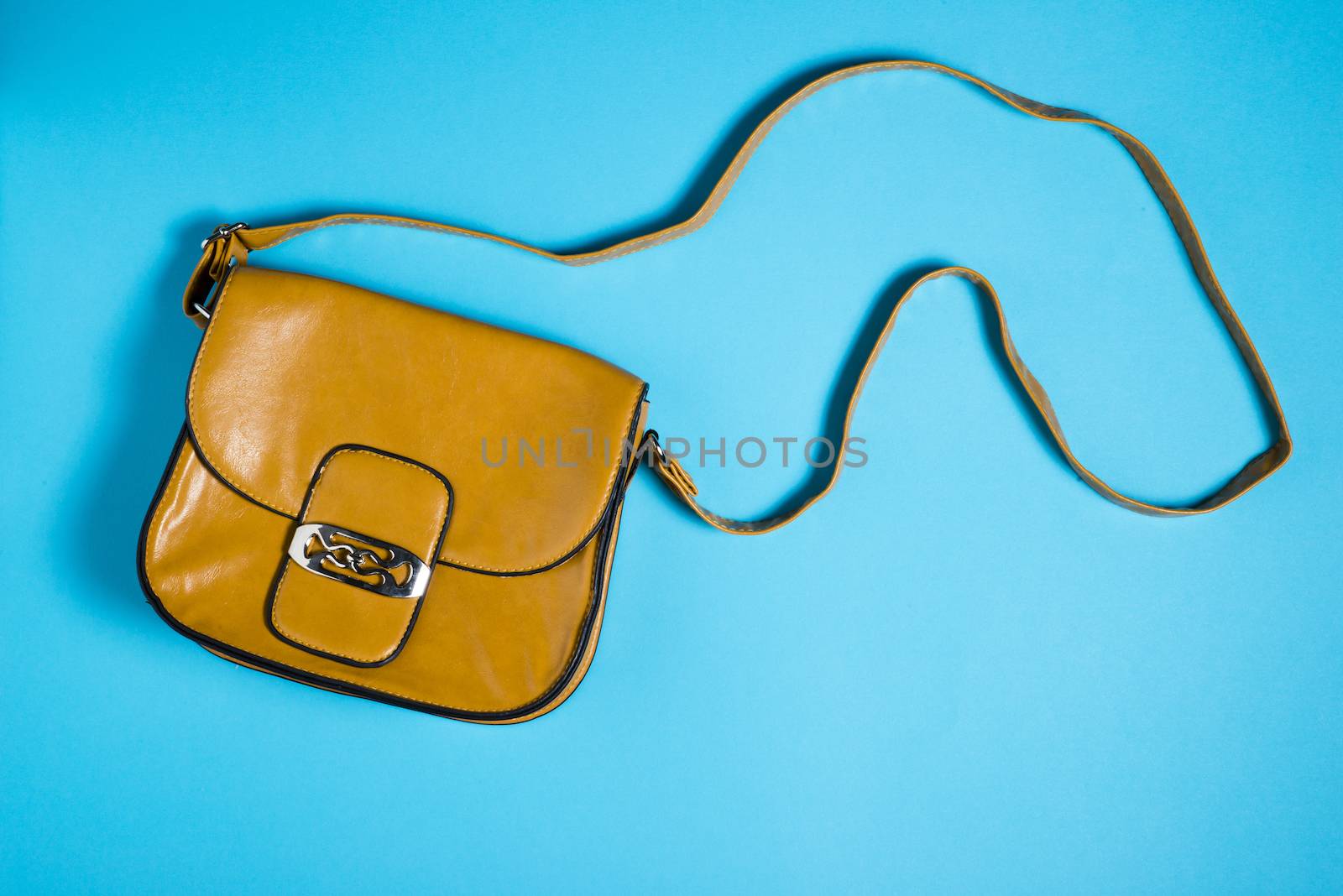 Woman leather purse on blue background by marius_dragne